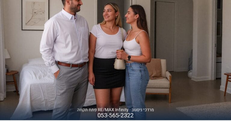 זוג צעיר מחייך ומתחבק בסלון מעוצב, כנראה בביתם החדש בפתח תקווה