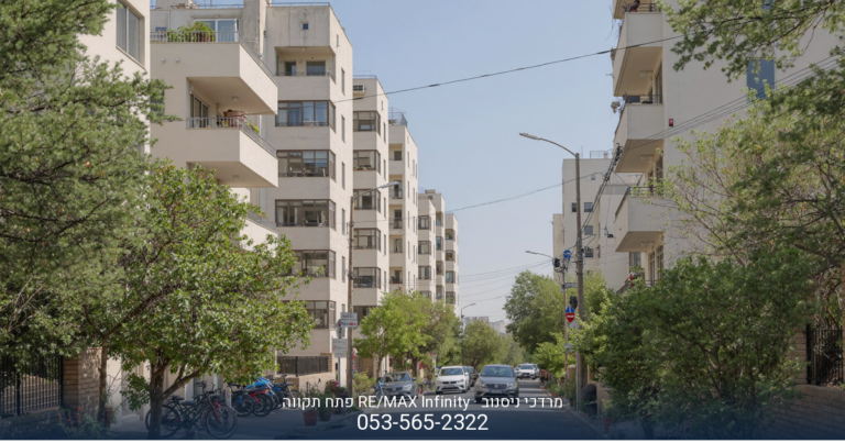 בניין מגורים מודרני בפתח תקווה באור יום, עם לוגו "מרדכי ניסנוב RE/MAX Infinity
