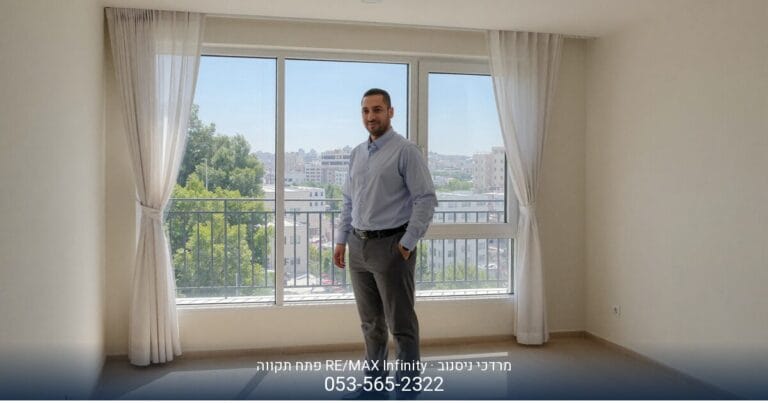 מרדכי ניסנוב מ-RE/MAX Infinity פתח תקווה עומד בסלון מרווח ושטוף אור בדירה למכירה