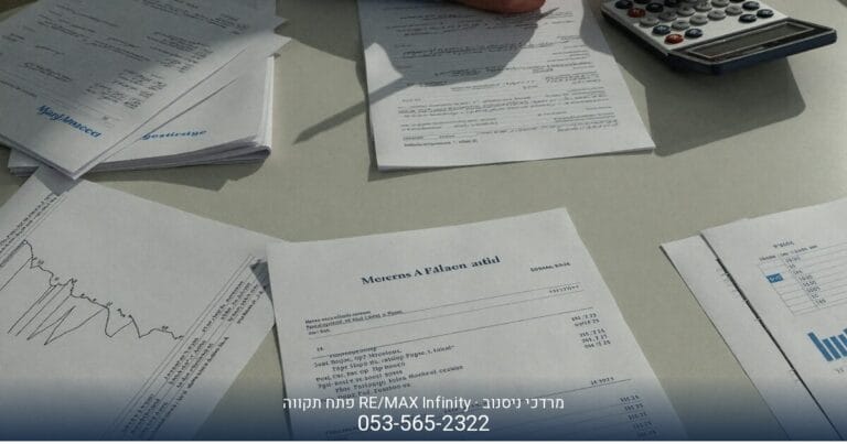 אצבע מצביעה על מסמכים ודף חישוב עם מחשבון, רמז למיסוי מקרקעין בפתח תקווה